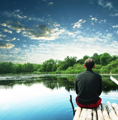 Man pondering on lake