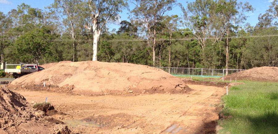 Earthworks site with stockpiled soil mound and survey markers, captured for volume survey and calculation of material quantities in Brisbane
