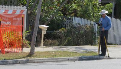Paul Reed using a total station on a suburban Brisbane street to measure residential property boundaries for identification survey.
