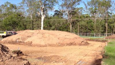 Earthworks site with stockpiled soil mound and survey markers, captured for volume survey and calculation of material quantities in Brisbane